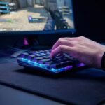 Jugador compitiendo en una partida de shooter utilizando uno de los mejores teclados para e-sports de 2026 con iluminación RGB y formato compacto.