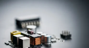 Gemini ha dicho Una toma de primer plano con enfoque selectivo de componentes electrónicos montados en una placa de circuito impreso de color negro.