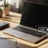 Laptop conectada a una batería externa, mostrando una carga del 95% en un entorno luminoso.