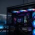 Vista en primer plano del interior de una PC de escritorio para videojuegos, destacando un sistema de refrigeración líquida AIO con iluminación RGB y una pantalla digital en el bloque de agua.