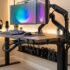 Un escritorio de computadora minimalista y ordenado, visto desde abajo, que muestra una gestión de cables impecable utilizando canaletas, clips y organizadores debajo de la mesa, con iluminación LED suave.
