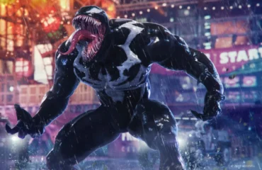 244-nate-the-hate-insomniac-sigue-desarrollando-juego-venom Venom, el simbionte negro con la lengua fuera, bajo la lluvia en una calle con luces de neón en Marvel's Spider-Man 2