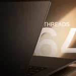 Portátil Sugon N50 Pro entreabierto, visto de lado, junto al rótulo 'THREADS 64' sobre un fondo marrón iluminado