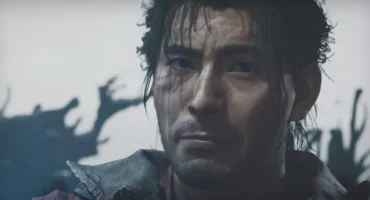 Rostro de un hombre con el pelo oscuro y mojado, expresión seria, ante un fondo desenfocado claro con siluetas de ramas