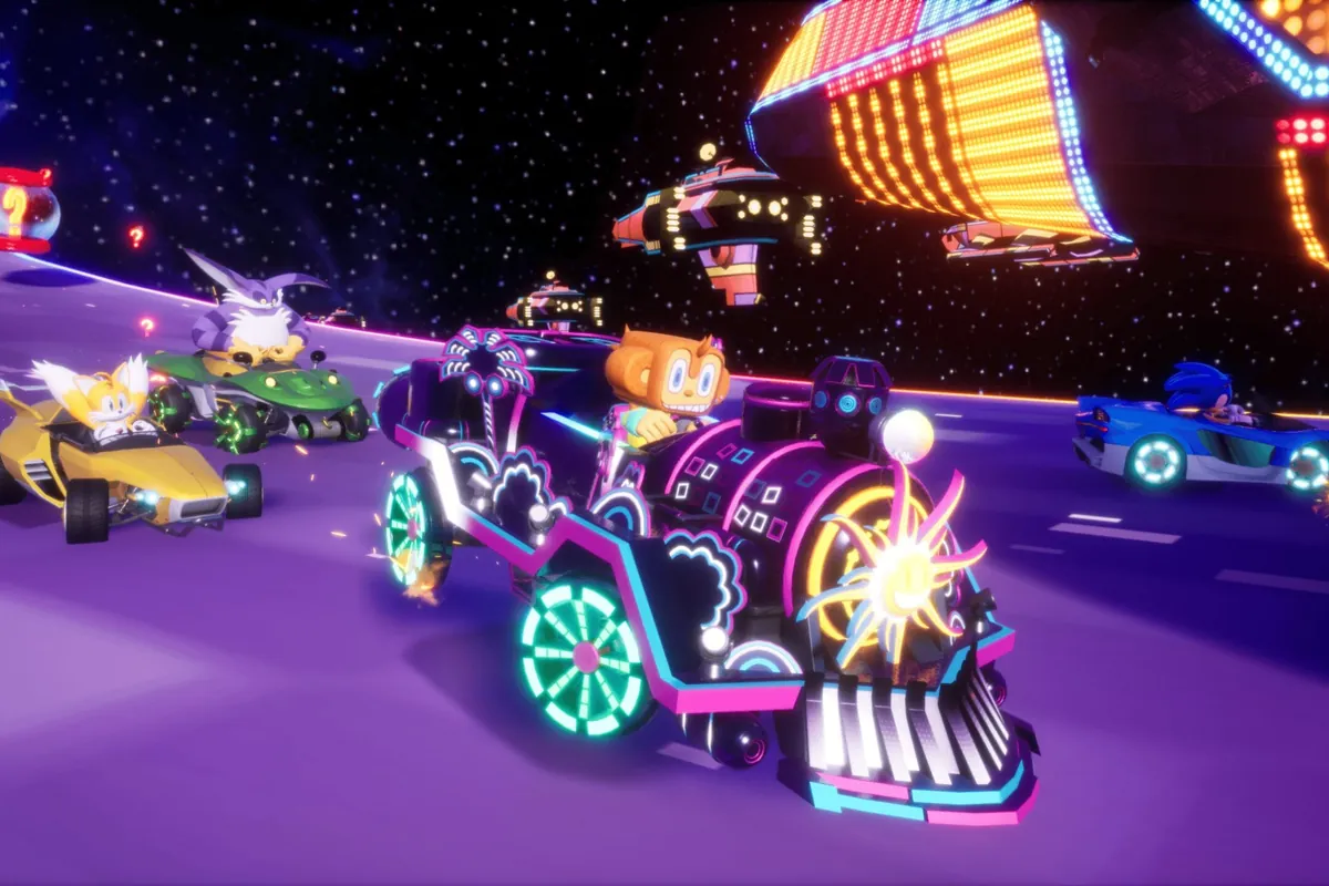 318-sonic-racing-crossworlds-amigo-samba-de-amigo-dlc-gratis Amigo, el mono de Samba de Amigo, conduce su locomotora en una pista espacial de Sonic Racing: CrossWorlds, con Tails y Sonic detrás