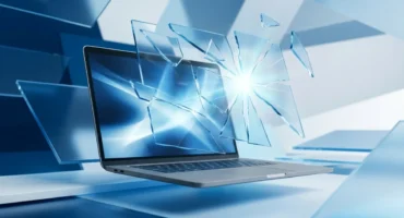 Portátil con pantalla luminosa rodeado de fragmentos de cristal que emanan luz, sobre una superficie blanca y azul. Imagen generada con IA.