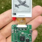 Placa verde con pantalla de tinta electrónica sostenida en una mano sobre césped