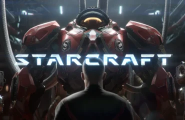 414-blizzard-anuncia-starcraft-shooter-2030 Un hombre de espaldas contempla una gran armadura de combate roja con el logotipo de STARCRAFT sobre ella, en un hangar futurista.