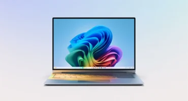 Portátil abierto con el fondo de pantalla de Windows 11 y la barra de tareas centrada