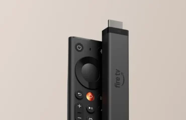 Foto oficial del nuevo Fire TV Stick 4K de Amazon junto al mando Fire TV Remote rediseñado, sobre un fondo beis