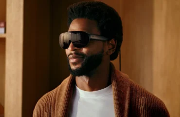 Un hombre con barba lleva las Meta VR Glasses, unas gafas oscuras de realidad virtual con un cable, en una habitación de madera