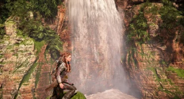 Escena de videojuego con una cascada entre paredes de roca y vegetación y una protagonista en primer plano, en una imagen de AMD de FSR 4