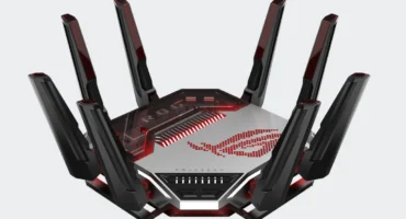 Router ASUS ROG Rapture GT-BN98 negro y plateado con sus antenas desplegadas y el logotipo de ROG iluminado en rojo, sobre fondo gris claro