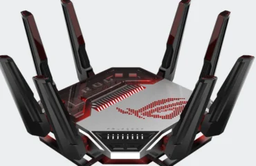 Router ASUS ROG Rapture GT-BN98 negro y plateado con sus antenas desplegadas y el logotipo de ROG iluminado en rojo, sobre fondo gris claro