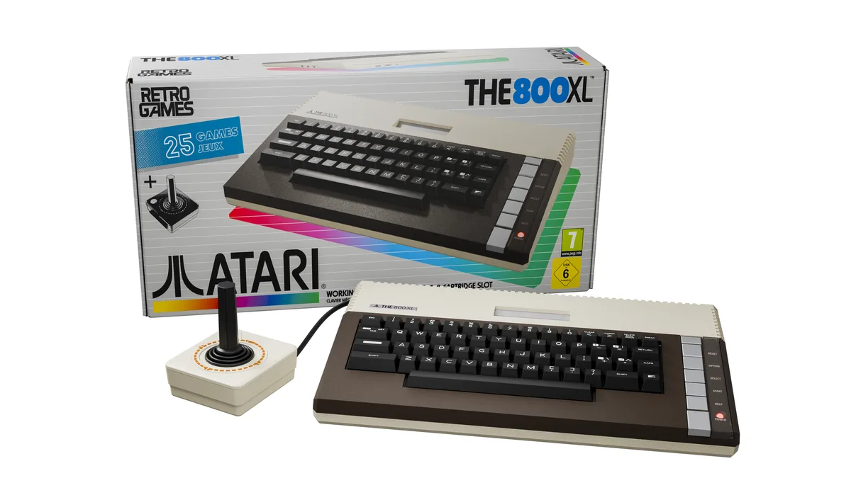 atari-800xl-retro-games-teclado-mecanico-hdmi THE 800XL de Retro Games, con su teclado marrón y crema, delante de su caja y junto al joystick THECXSTICK