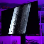 Monitor MSI MPG 321URX QD-OLED sobre una mesa en la sala de pruebas de TechSpot, con luz morada, durante la prueba de quemado de 30 meses