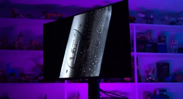 Monitor MSI MPG 321URX QD-OLED sobre una mesa en la sala de pruebas de TechSpot, con luz morada, durante la prueba de quemado de 30 meses