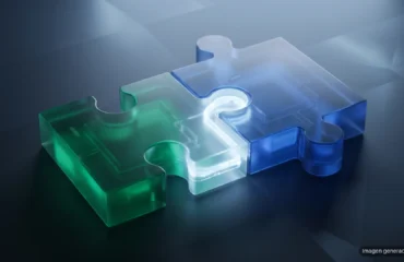 Dos piezas de puzle de cristal esmerilado, una verde y otra azul, encajando sobre una mesa oscura con un haz de luz. Imagen generada con IA.