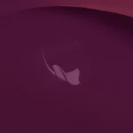 Fondo de escritorio oficial de Ubuntu 26.10: una mantarraya dibujada con puntos sobre un fondo granate con curvas suaves