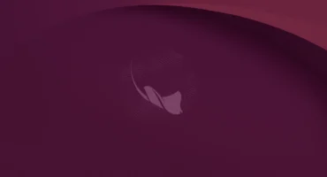 Fondo de escritorio oficial de Ubuntu 26.10: una mantarraya dibujada con puntos sobre un fondo granate con curvas suaves
